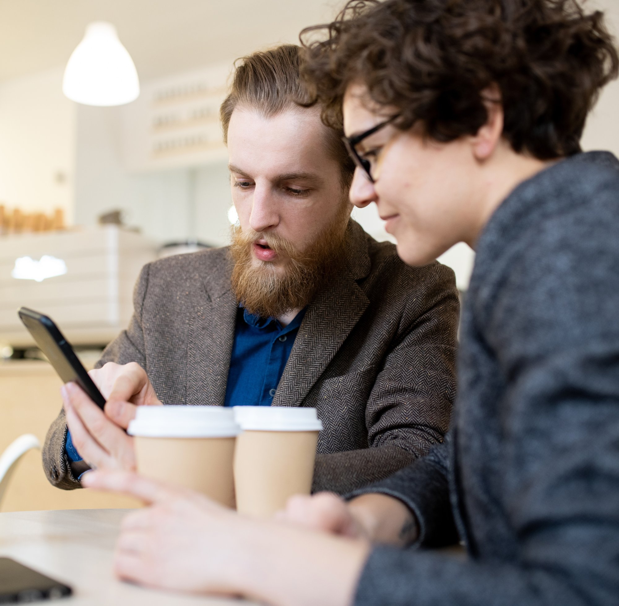 colleagues-analyzing-information-smartphone-cafe